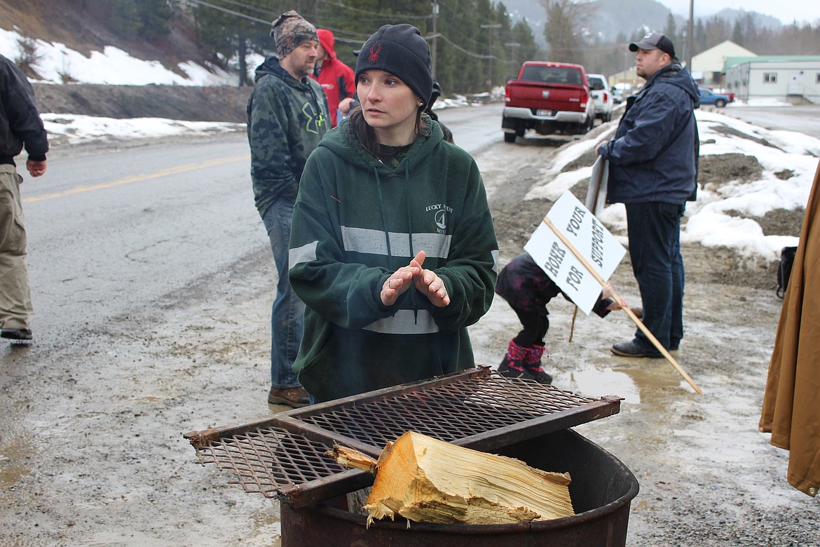 Jamie Assels gets warm next to a burn barrel at the other picket line on Friday Ave.