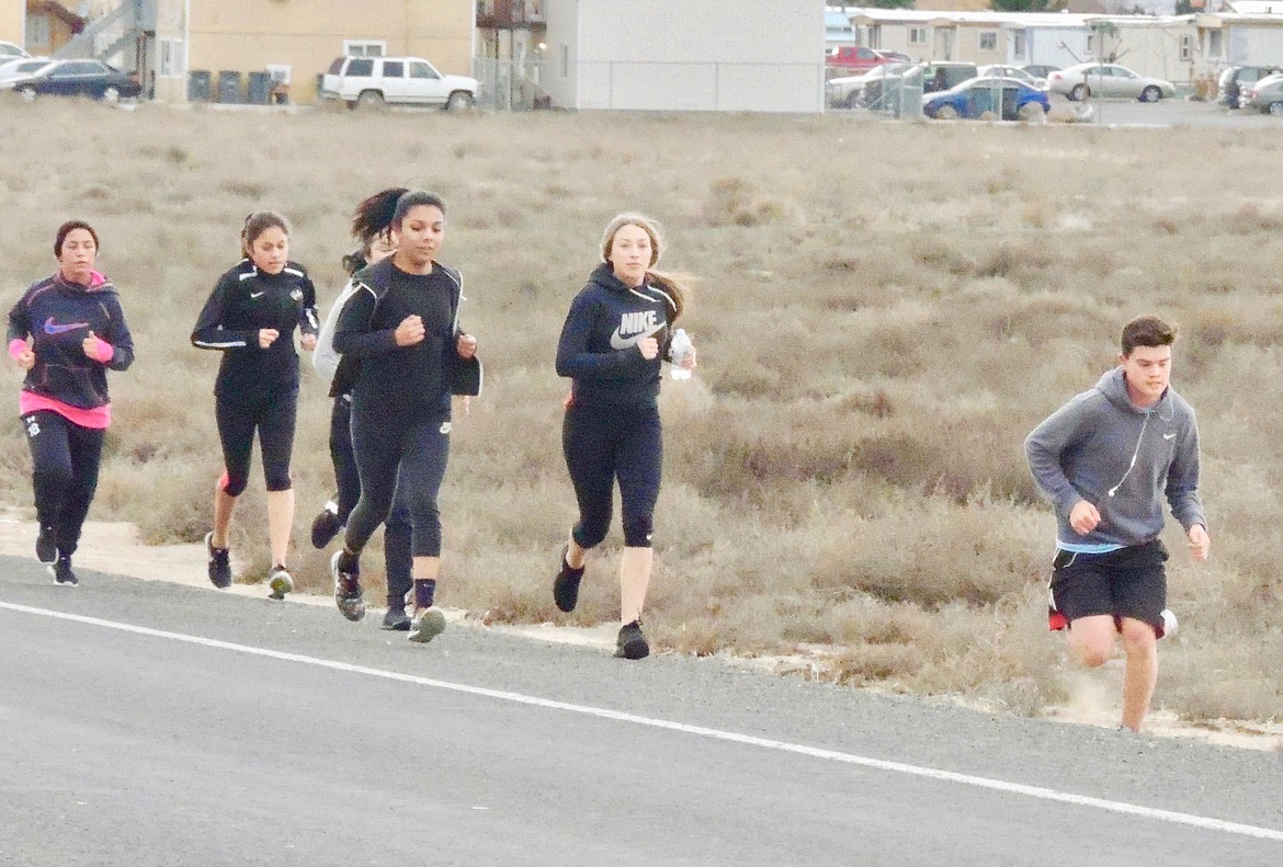 Ted Escobar/The Sun Tribune - The distance runners put in the necessary long miles on Road 24 SW, heading east as far as they can go.