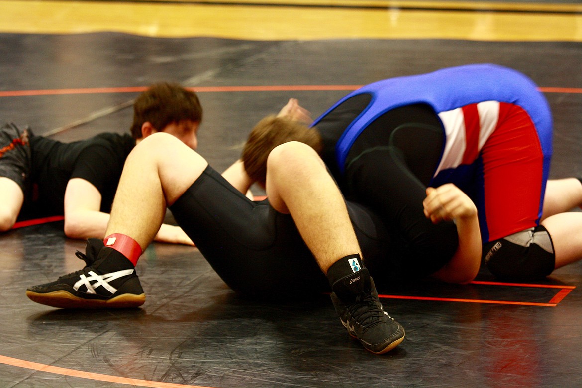 Tim Gallerneau from Superior (in the blue red and black) is seconds away from the &#147;unofficial&#148; pin of Adam Aguillera from Plains/Hot Springs (in black).