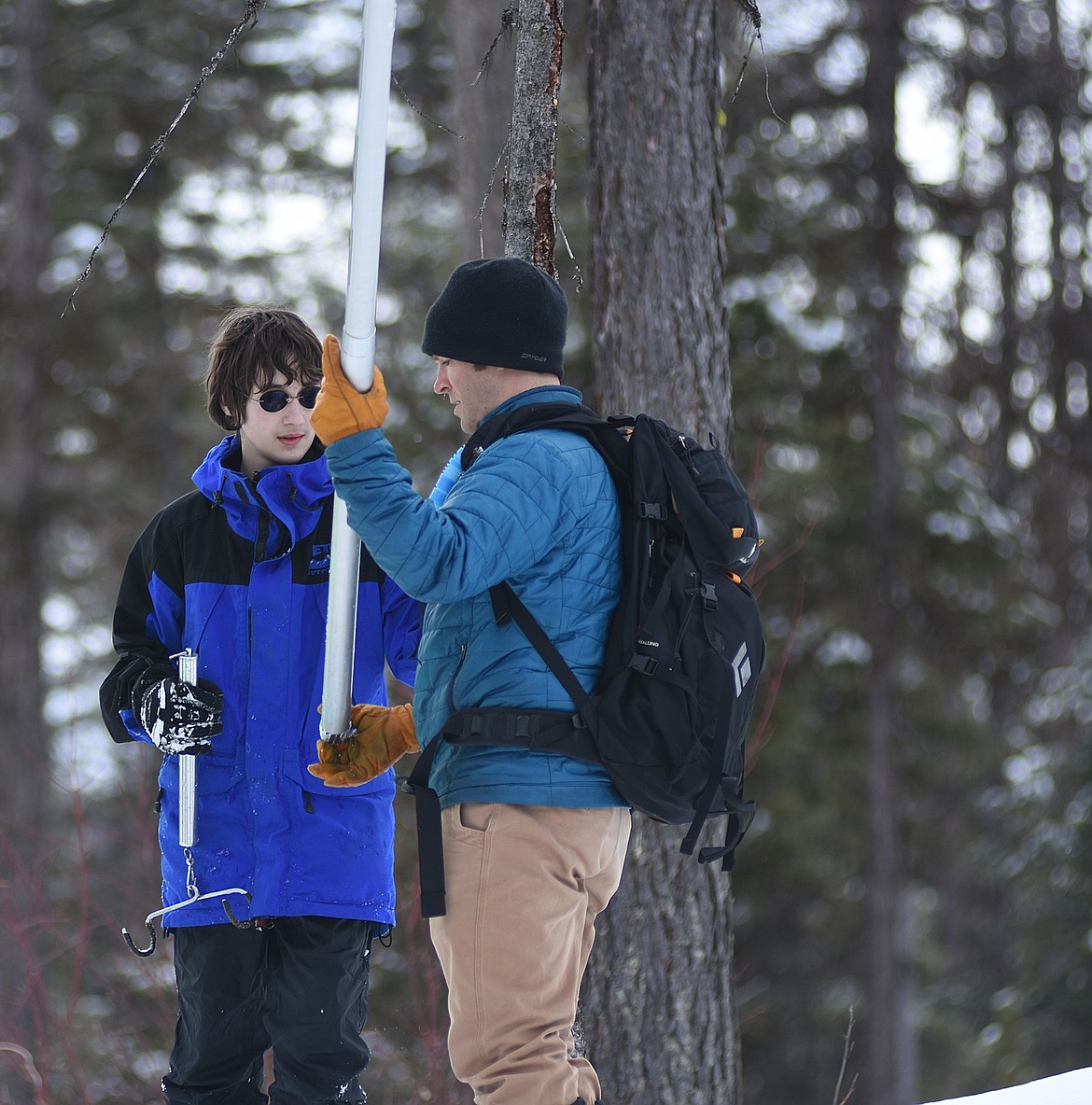 Teacher Shawn Lenzner works with Max Wood to measure snow depth.