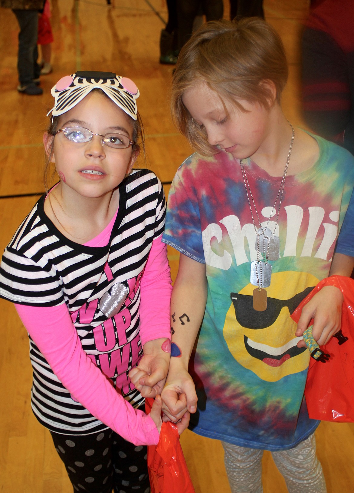 Emma McCrae, left, and Ireland Corbin show the hearts that were painted onto their arms during the National Honor Society carnival held after school.