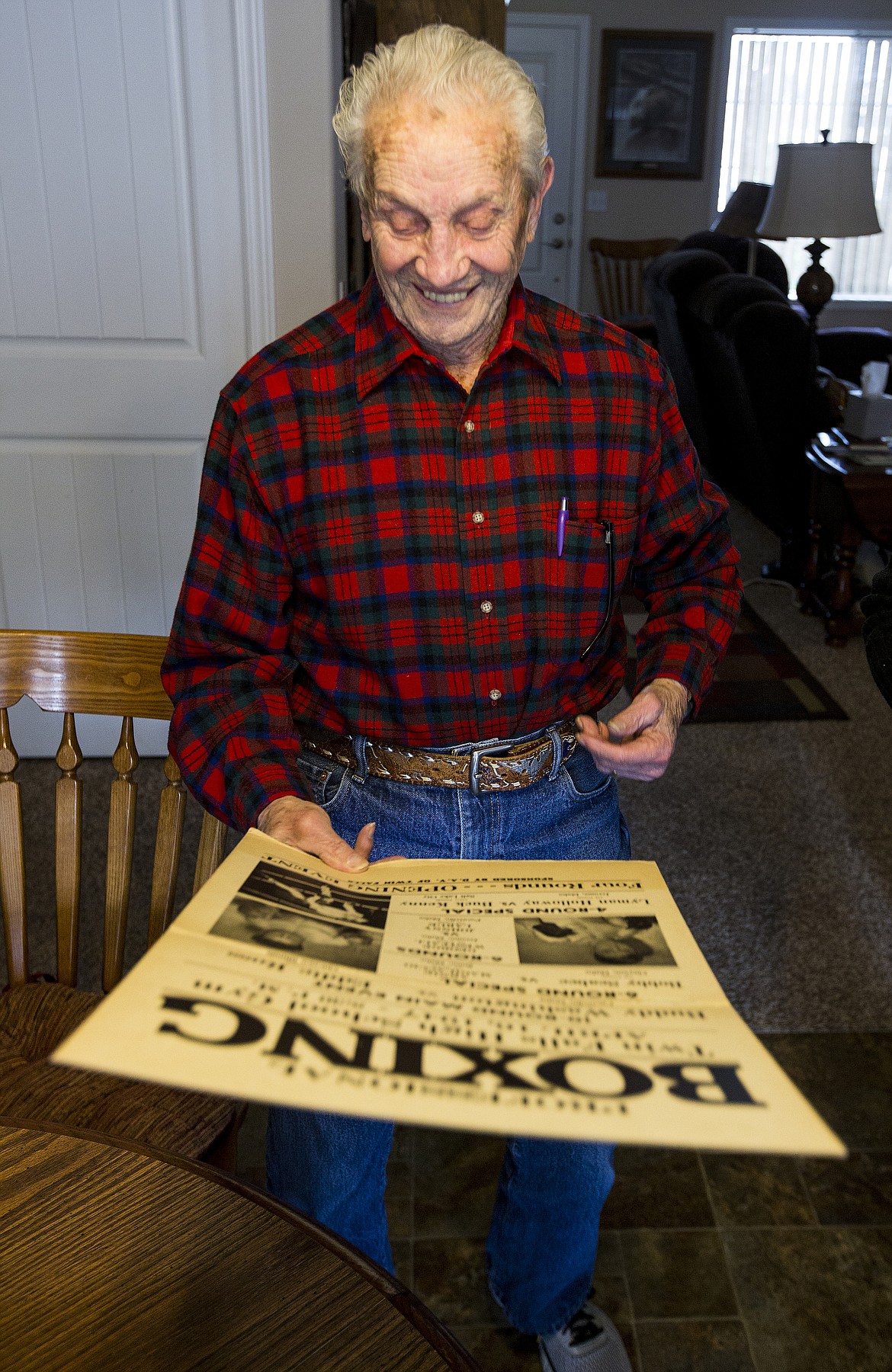 Bob Eachon smiles as he holds a poster advertising one of his boxing matches at Twin Falls High School in 1947.