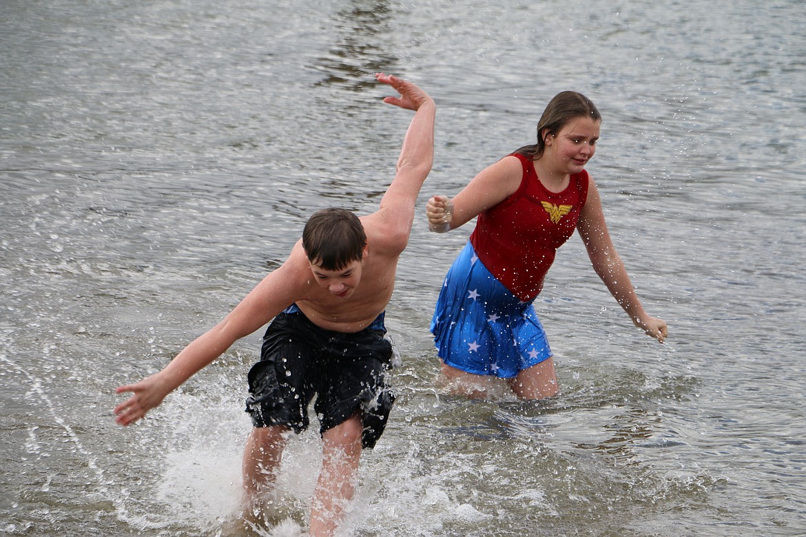 Cousins Ben and Zoe Rasor race out of the water at City Beach Saturday after a competition to see who could stay in the longest ended in a tie after about a minute in the 43-degree lake during the annual Penguin Plunge.
(Photo by 
MARY MALONE)