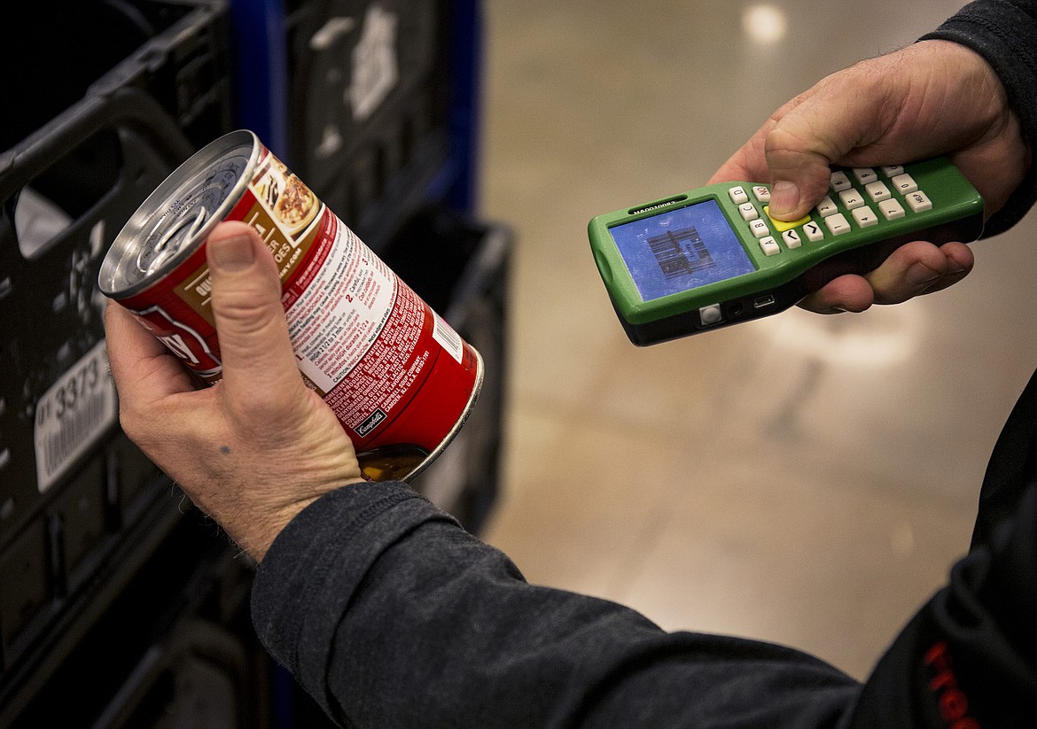 LOREN BENOIT/PressFred Meyer employee Manny Tavison scans a can of soup before placing it into a ClickList container.