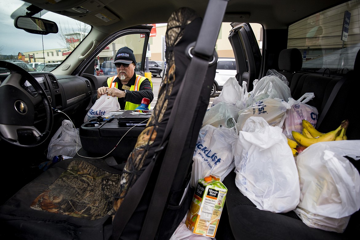 LOREN BENOIT/PressFred Meyer employee Manny Tavison places ClickList groceries inside Andy Ost's truck Wednesday afternoon. ClickList is a program in which a customer can order grocery items online and then drive to Fred Meyer to have them delivered.