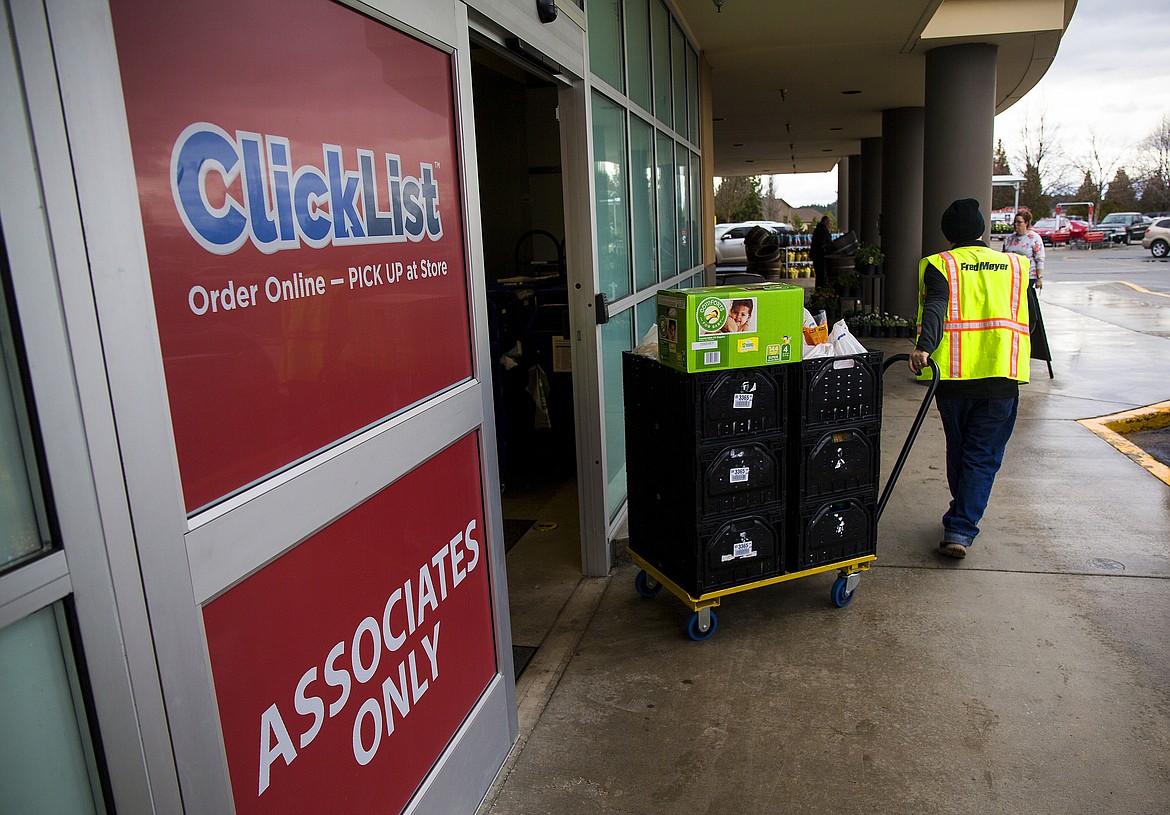 LOREN BENOIT/Press

Fred Meyer employee Manny Tavison pulls a cart full of  groceries for a ClickList customer to pickup Wednesday afternoon. The store charges $4.95 per order to pick, pack and bring the groceries out to the car, with no charge for the first three orders.