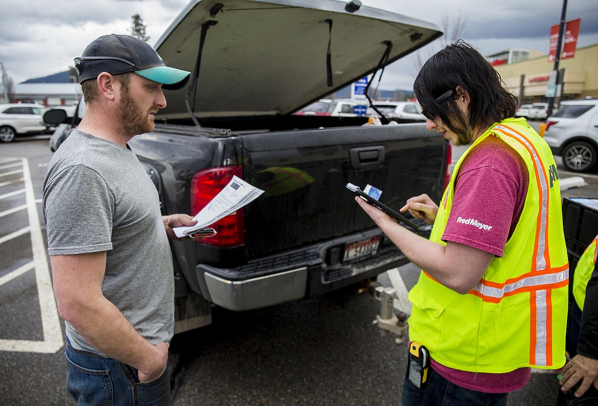 LOREN BENOIT/PressFred Meyer employee Chris Morton inputs Andy Ost's Clicklist grocery pickup order on his iPad Wednesday morning. Ost and his wife have eight kids and shopping through ClickList has given his wife more time to plan meals and spend time with their kids.