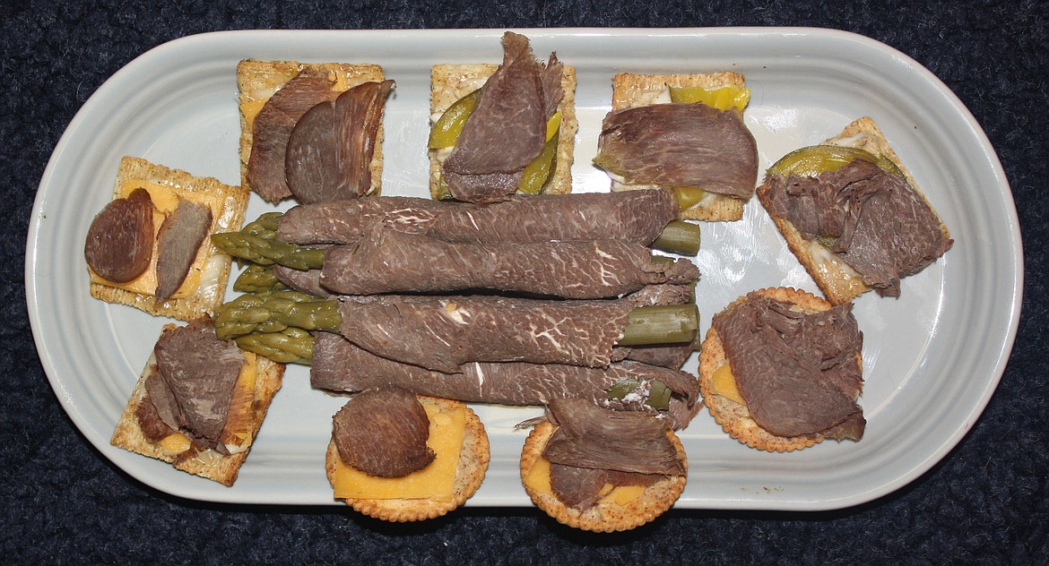 Dennis L. Clay photo
Appetizers ready to serve:
The three appetizers on the left are made of mayonnaise on the cracker, followed by cheddar cheese and then goose breast. The three on the top-right have both mustard and mayonnaise, plus cheese, pickle and goose breast. The three round crackers have mustard on the cracker, cheese and goose. The goose slices are so thin, the cream cheese can be seen trying to seep through.