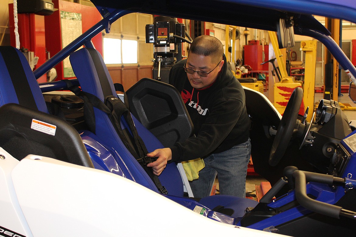 Cheryl Schweizer/Columbia Basin Herald
Tim Shimura Jr. carefully adjusts the belts in his side-by-side ORV, on display at the MLHS car show Saturday.