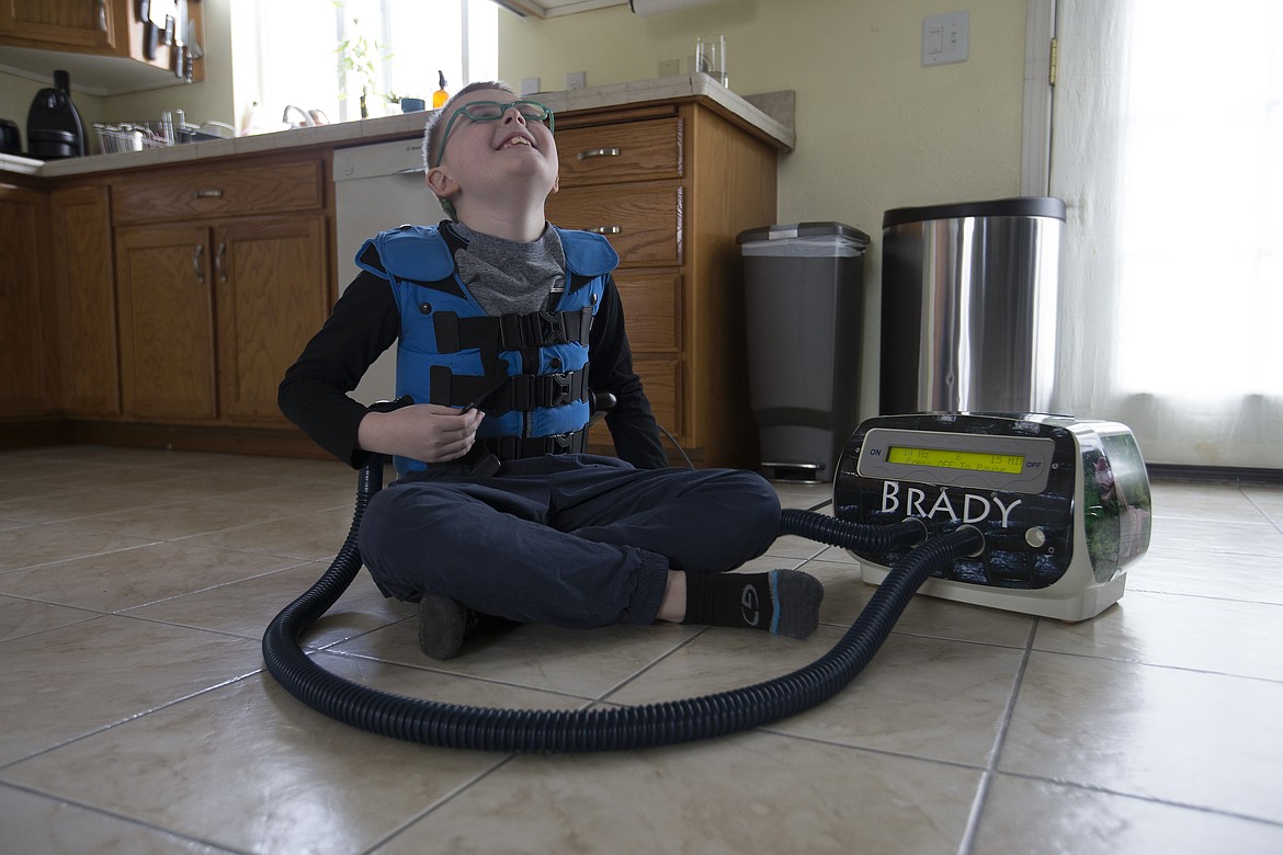 LISA JAMES/PressBrady Schroeder, 9, giggles as his chest wall oscillator makes his lung vibrate by pumping air into his vest.The vibrations help Brady breathe by breaking up the fluid on his lungs which are a condition of his cystic fibrosis.Brady's family was able to afford the $16,000 machine, and his needed medications, through the Affordable Care Act.