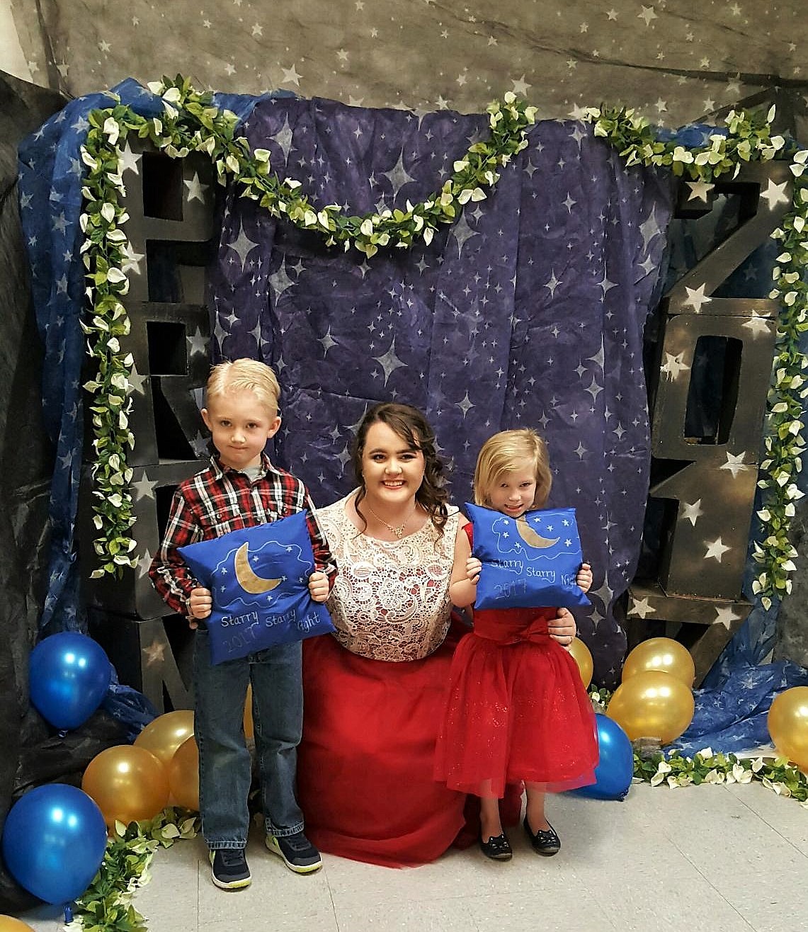 Crown bearers Luca Digiando, 6, and Sidney Kuhl, 4, pose with Superior student Sammi Francis. (Photo by Kate Digiando)