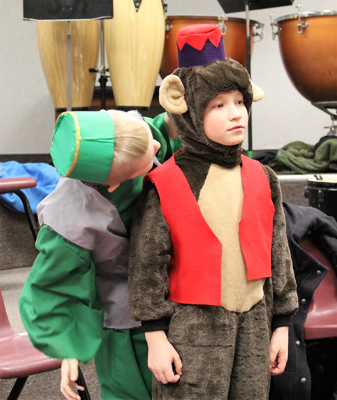 A friend whispers to Joseph Farris, who plays the monkey Abu, backstage before the play starts.
