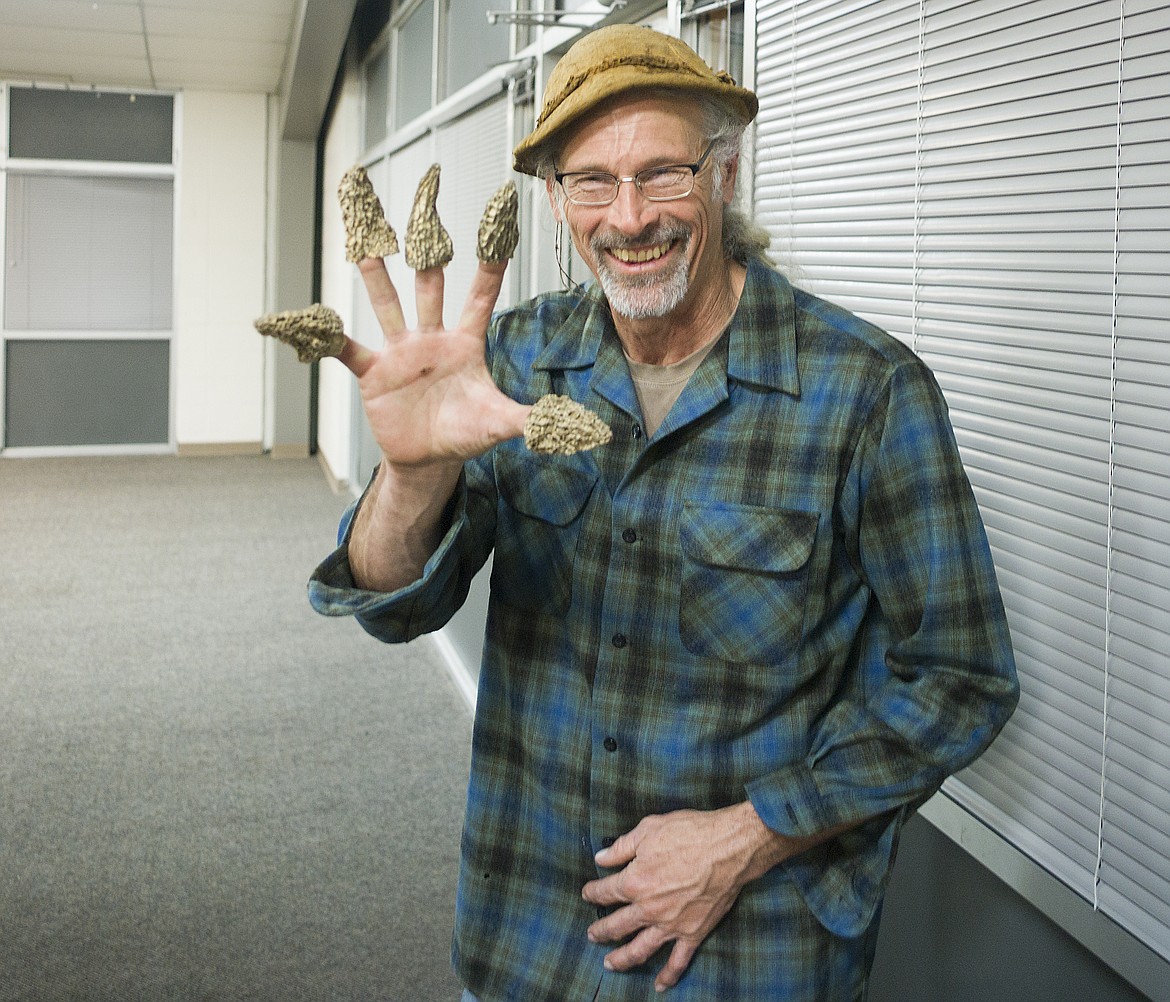 Mycologist Larry Evans wears a handful of morels.