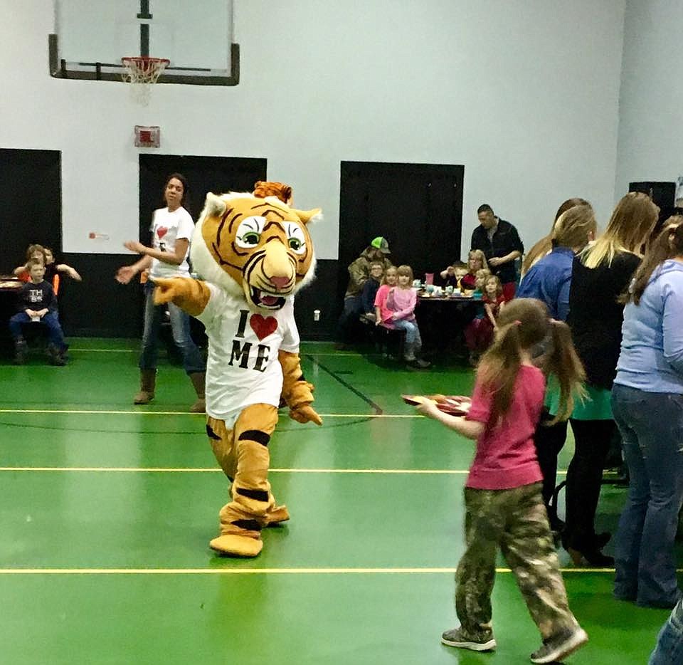 St. Regis tiger mascot dances as part of a flash mob performed in the school cafeteria to discourage the use of tobacco products during Kick Butts Day on Mar. 15. (Photo courtesy St. Regis School Facebook).