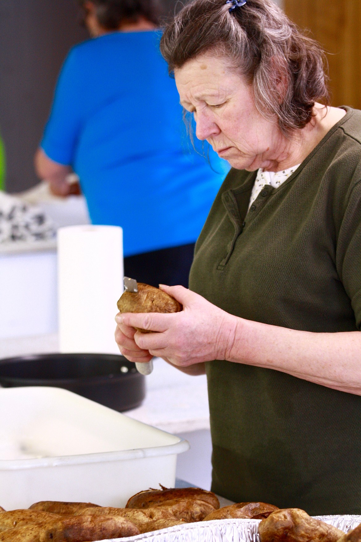 TERRI HENRY slices Washington-grown potatoes for the National Wild Turkey Federation auction and dinner. (Douglas Wilks photos/Clark Fork Valley Press)