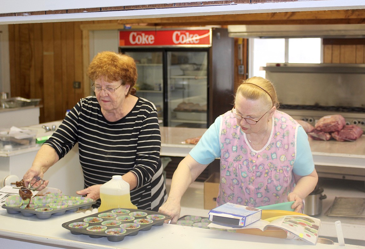 SHIRLEY NETTLETON and Pat Farmer prepare cupcakes for the National Wild Turkey Federation dinner and auction at the Sanders County Fairgrounds.