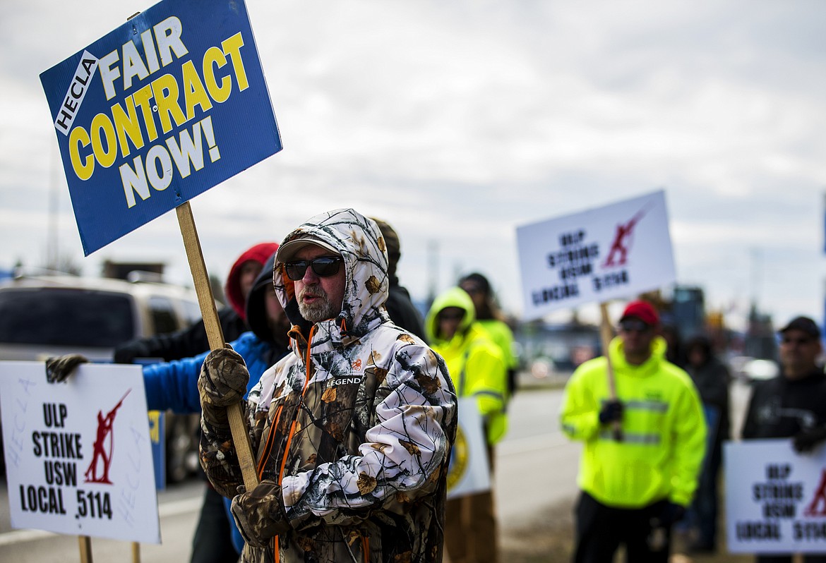 LOREN BENOIT/PressMiner Ike Hopper holds a sign as he stands on a picket line against Hecla Mining Monday morning along U.S. 95 south of Canfield Avenue.