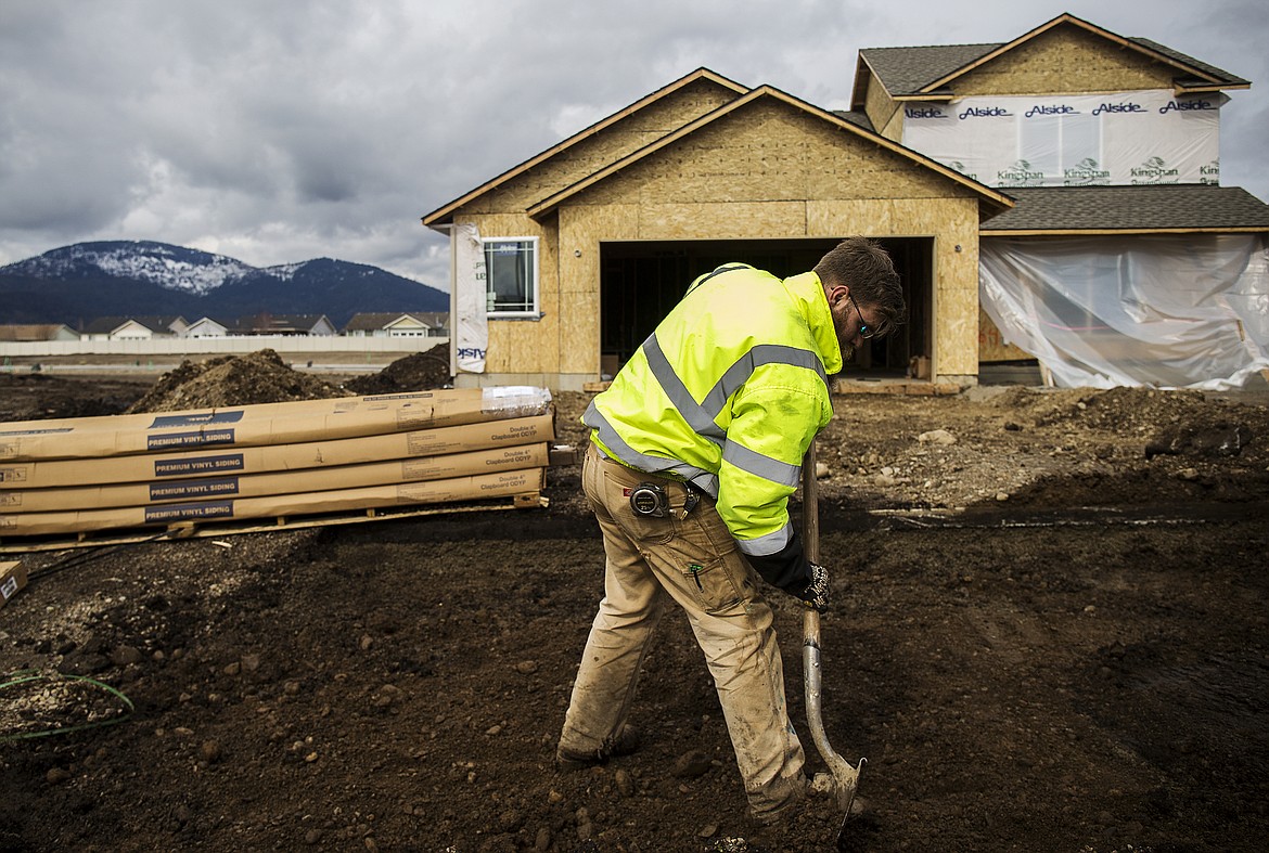 LOREN BENOIT/PressMatthew Benjamin levels the approach of a driveway before a truck pours cement Thursday afternoon. Rathdrum is on pace to break its record for the number of single-family home building permits issued in a year.