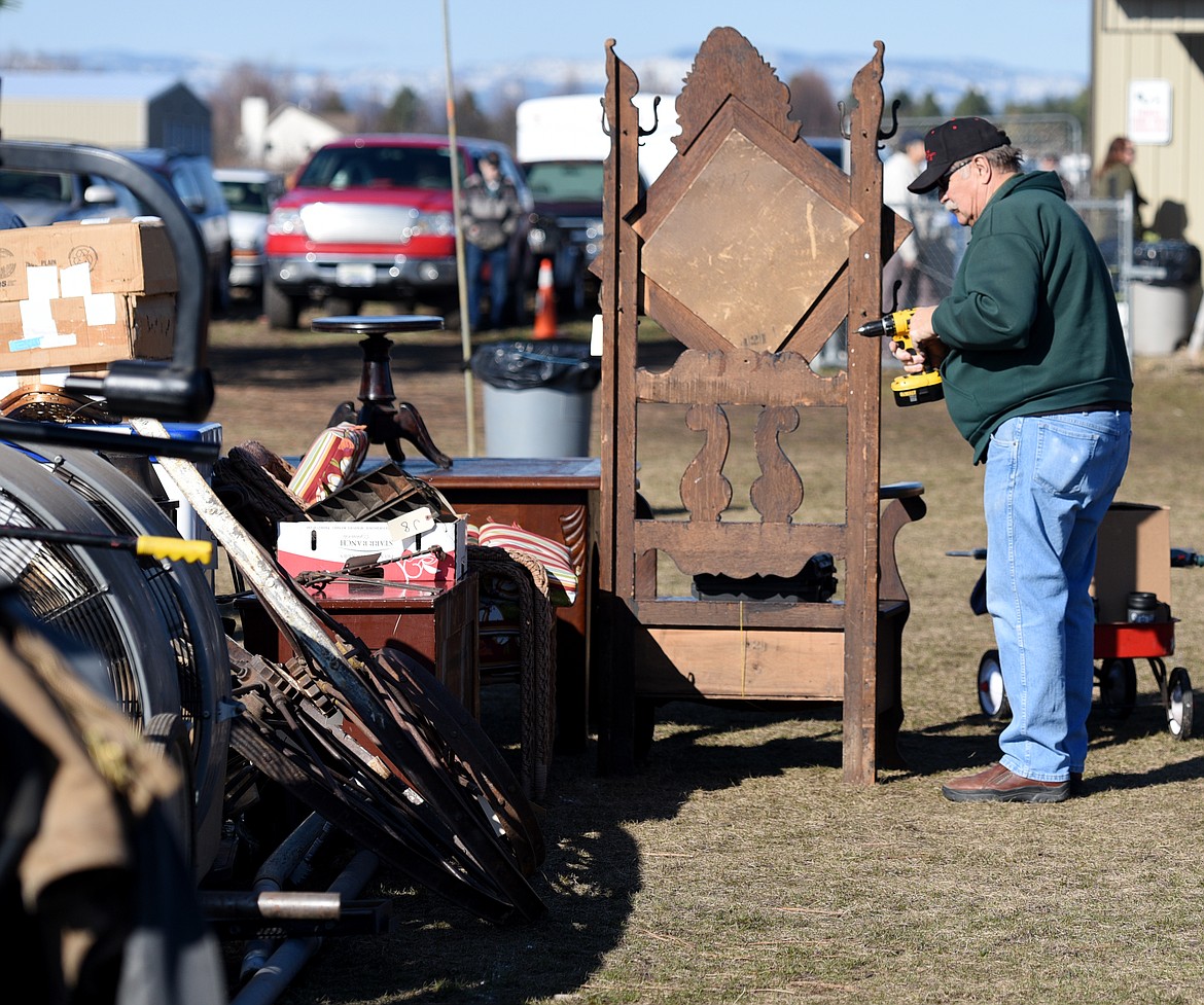 Karl Apple drills a mirror on the hall tree he brought to the Creston Auction. (Daily Inter Lake FILE)