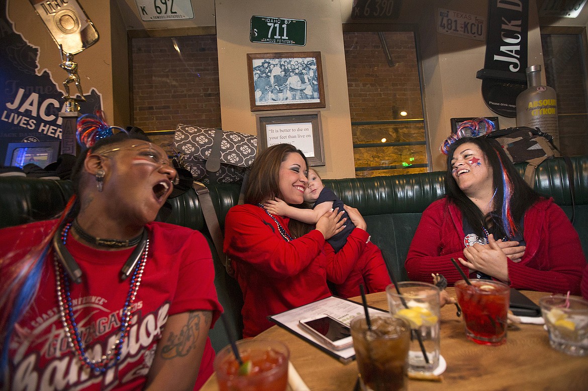 Patrice Thompson-Rose, left, joins her friends and fellow Zag fans Christylee Comrie, center, with son Greyson Yates, 1, and Trish Comrie, at Crickets to cheer on Gonzaga Monday night. The Bulldogs fell to the Tar Heels 71-65 in the final seconds but completed their most successful season ever.