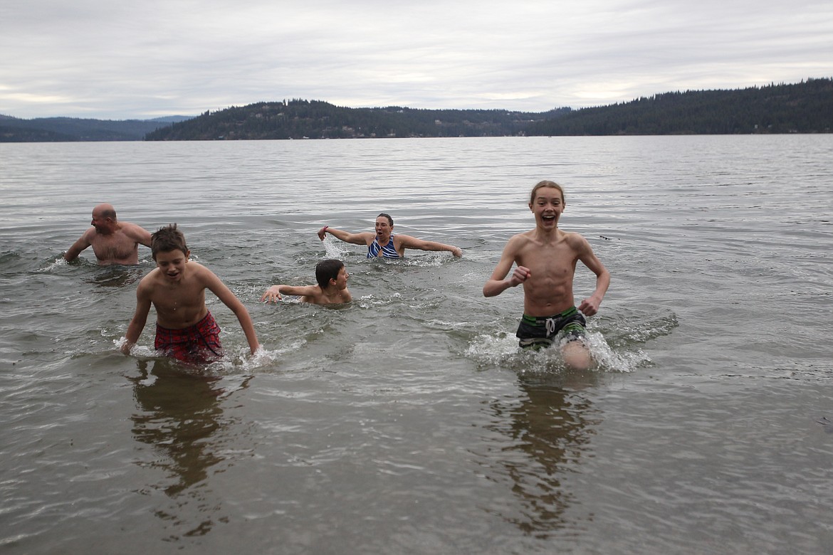 DEVIN HEILMAN/Press
Zane Pomerantz, 13, right, of Coeur d&#146;Alene, springs out of Lake Coeur d&#146;Alene with 12-year-old twin brothers Frey, center, and Ashton, left, as mom Kirsten reacts to the chilly temperatures. The family joined about 10 others who jumped in Saturday during the Penguin Plunge.