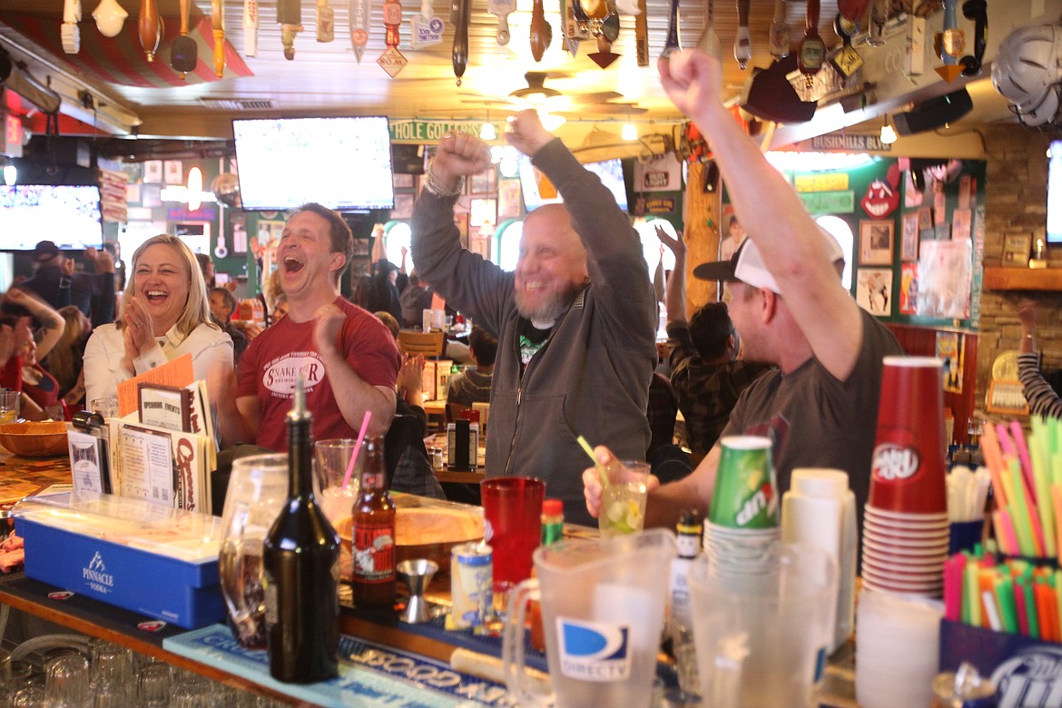 DEVIN HEILMAN/Press
Monica Brennan, left, and David Ewell of Coeur d'Alene join Duane Justis of Hauser and Scott Anderson of Coeur d'Alene in celebrating the Gonzaga men's basketball victory Saturday in Capone's.