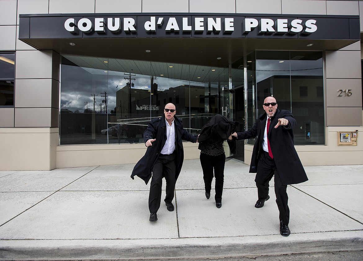 LOREN BENOIT/Press
Federal agents identified only as Thing 1 and Thing 2 rush reporter April Fuhl from the Coeur d&#146;Alene Press building Friday evening. Fuhl was charged with 14 counts of perpetuating fake news, potentially a capital offense.