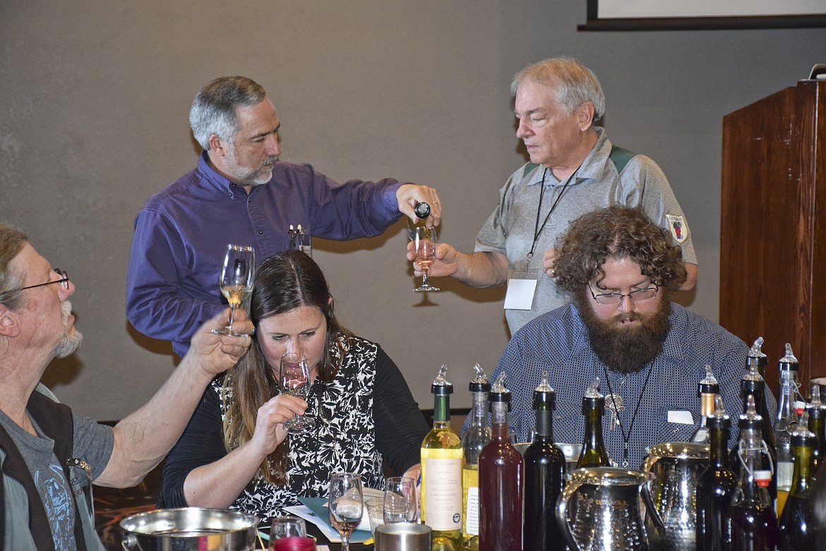 Caressa Bailey Sacks, center, of the Big Sky Wine and Spirits Academy samples wine at the Montana Grape and Winery Association&#146;s spring convention at the KwaTawNuq Resort in Polson on Friday. (Brett Berntsen/Lake County Leader)