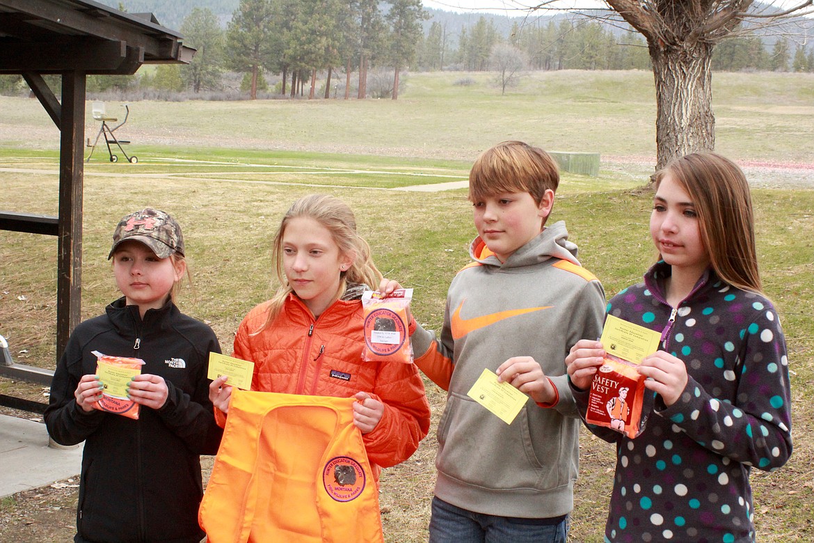 from left: Kaylie Peele, Ayda Griffin, Tyson Brouilette, Marissa Young hold their Hunter Education certificate and blaze orange hunter Safety vest with the patch sewn on it.