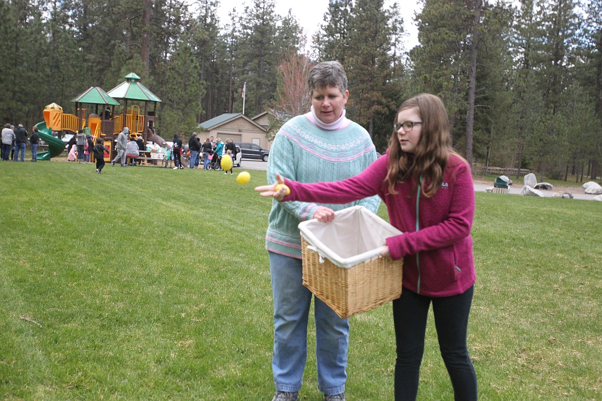 DEVIN HEILMAN/Press
Hannah Adams, 11, and her mom, Coeur d'Alene School District vision teacher Melissa, toss out plastic eggs before Saturday's beeping egg hunt in Kiwanis Park in Post Falls.