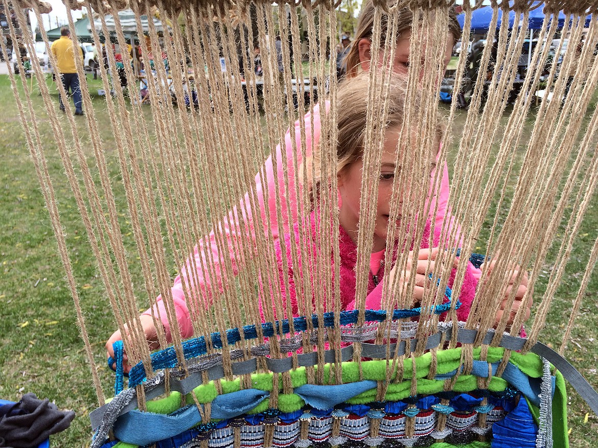 TWO GIRLS are weaving during the 2015 Flathead Earth Day celebration.