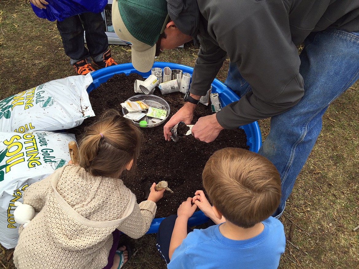 VISITORS LEARN about planting, and do a little planting of their own, at the 2016 celebration.