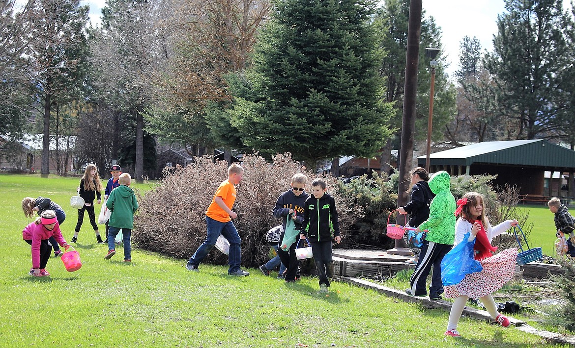 The older kids scout around the flag pole searching for eggs and candy. (Kathleen Woodford/Mineral Independent).