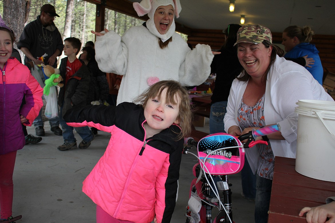 Marley Downing, 5, won the girls bike in a raffle during the Easter Egg Hunt, donated by Tricon Timber with Easter Bunny Amanda Scott, Kassie Perkins (right) and older sister, Madison (left). (Kathleen Woodford/Mineral Independent).