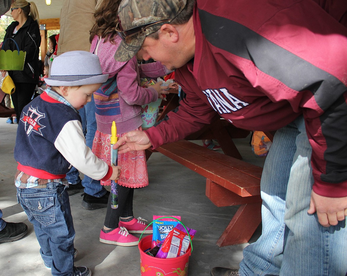 Seger Triplett, 2, examines a toy with his dad. (Kathleen Woodford/Mineral Independent).