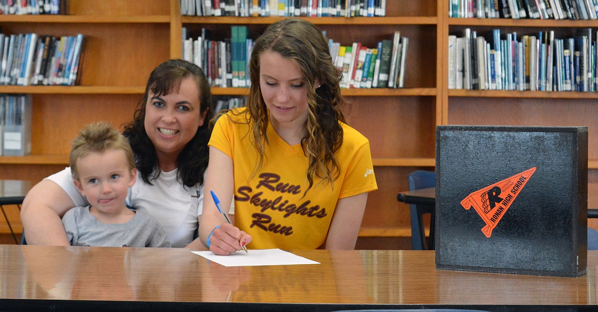 ASHLEY MCCREADY signs a letter of intent at Ronan High School Wednesday to run with Montana State-Northern. (Jason Blasco/Lake County Leader)