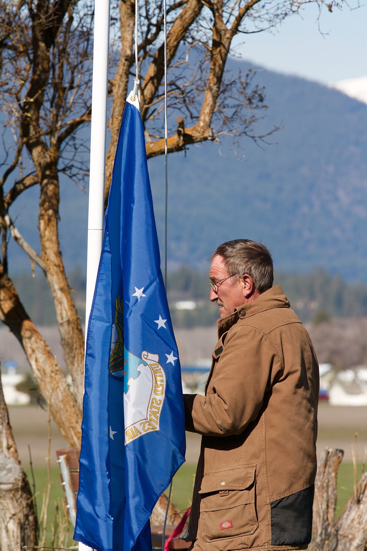 PLAINS CEMETERY sexton Ken Jones works with the United States Air Force flag at the Plains cemetery. (Douglas Wilks photos/Clark Fork Valley Press)