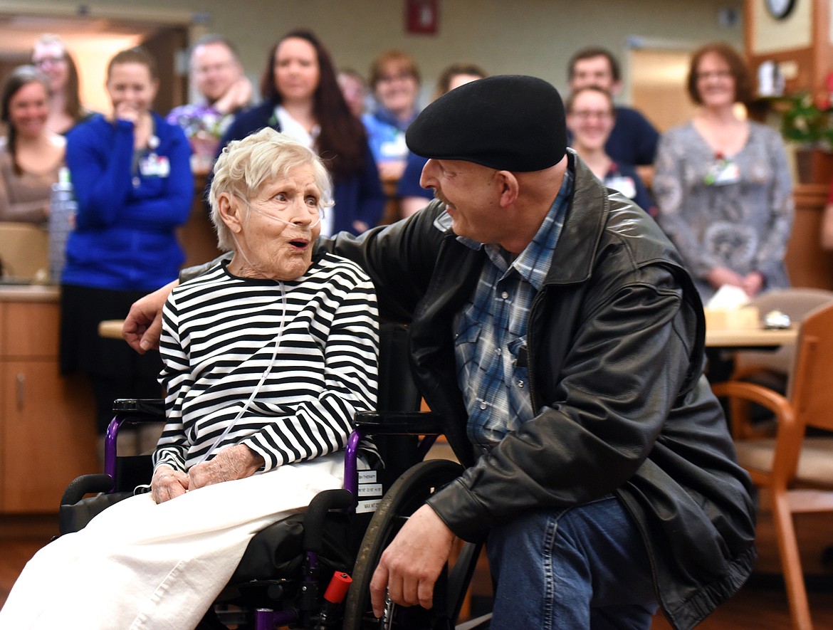 Carroll Krause reacts with surprise and tears of joy as her son Greg Cook, right, informs her that her grandson, whom she has not seen since 2006, is coming to see her at Brendan House in Kalispell. In the background the staff gather around to cry and applaud for this special family moment.