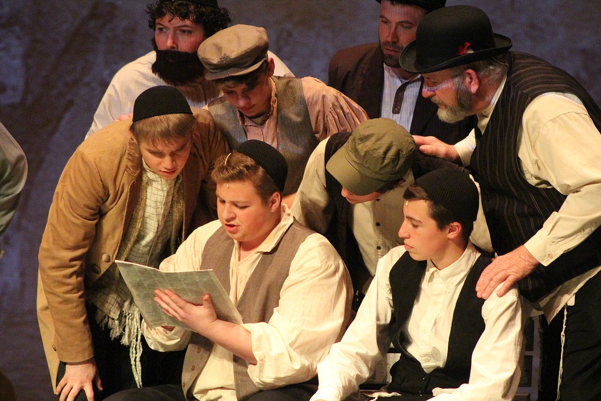 Richard Byrd/Columbia Basin Herald
Townspeople gather around a newspaper during &#145;Fiddler on the Roof&#146; Friday night to glean the latest news.