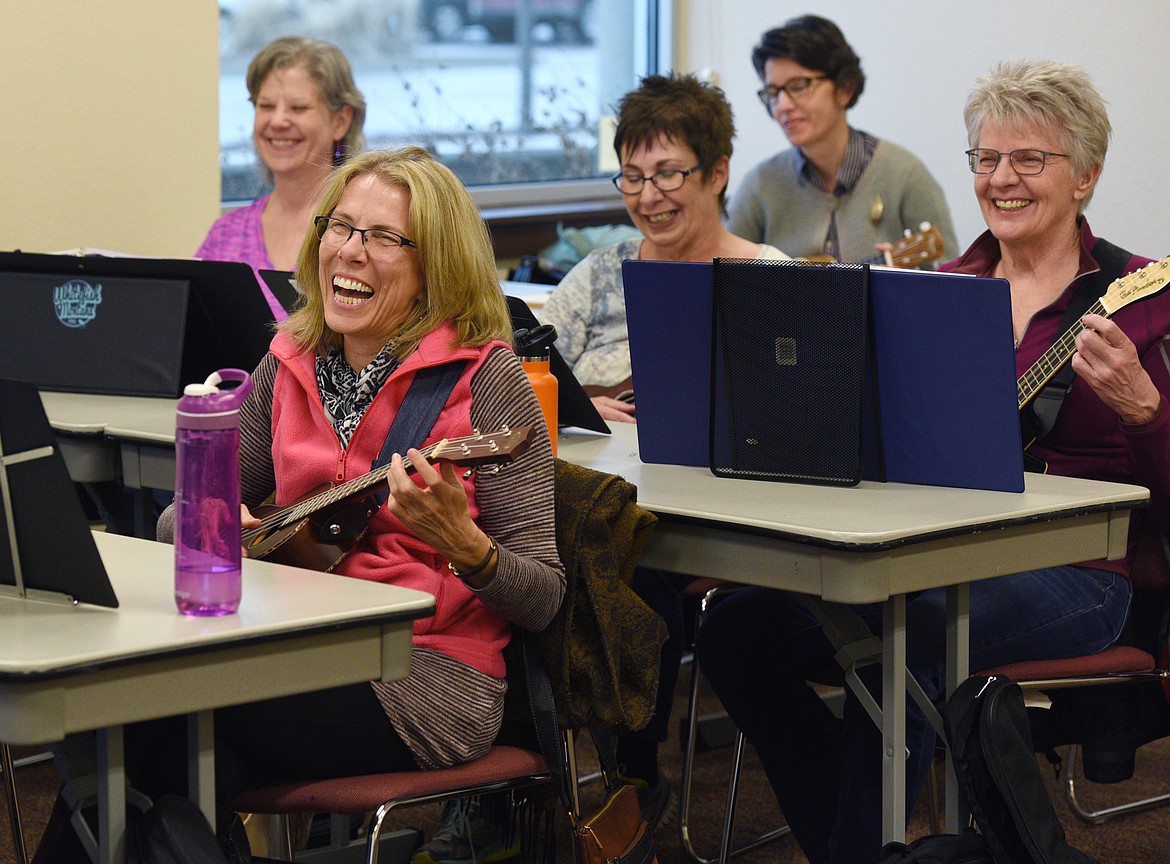 Beth Schecher laughs after finishing a song during a Flathead Valley Community College continuing education intermediate ukelele course on Thursday. (Aaric Bryan/Daily Inter Lake)