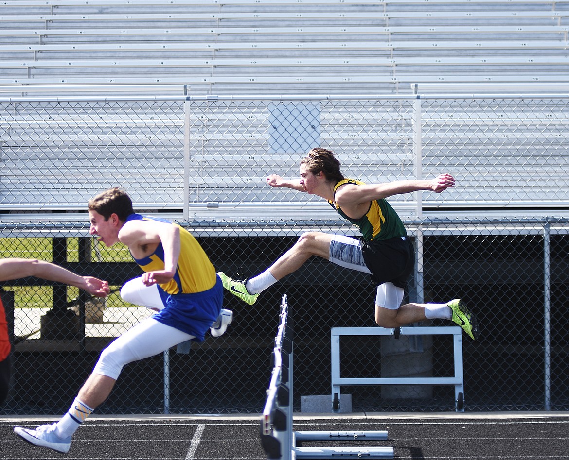 Lee Walburn is neck and neck with a Libby hurdler at Legends Field on April 4.