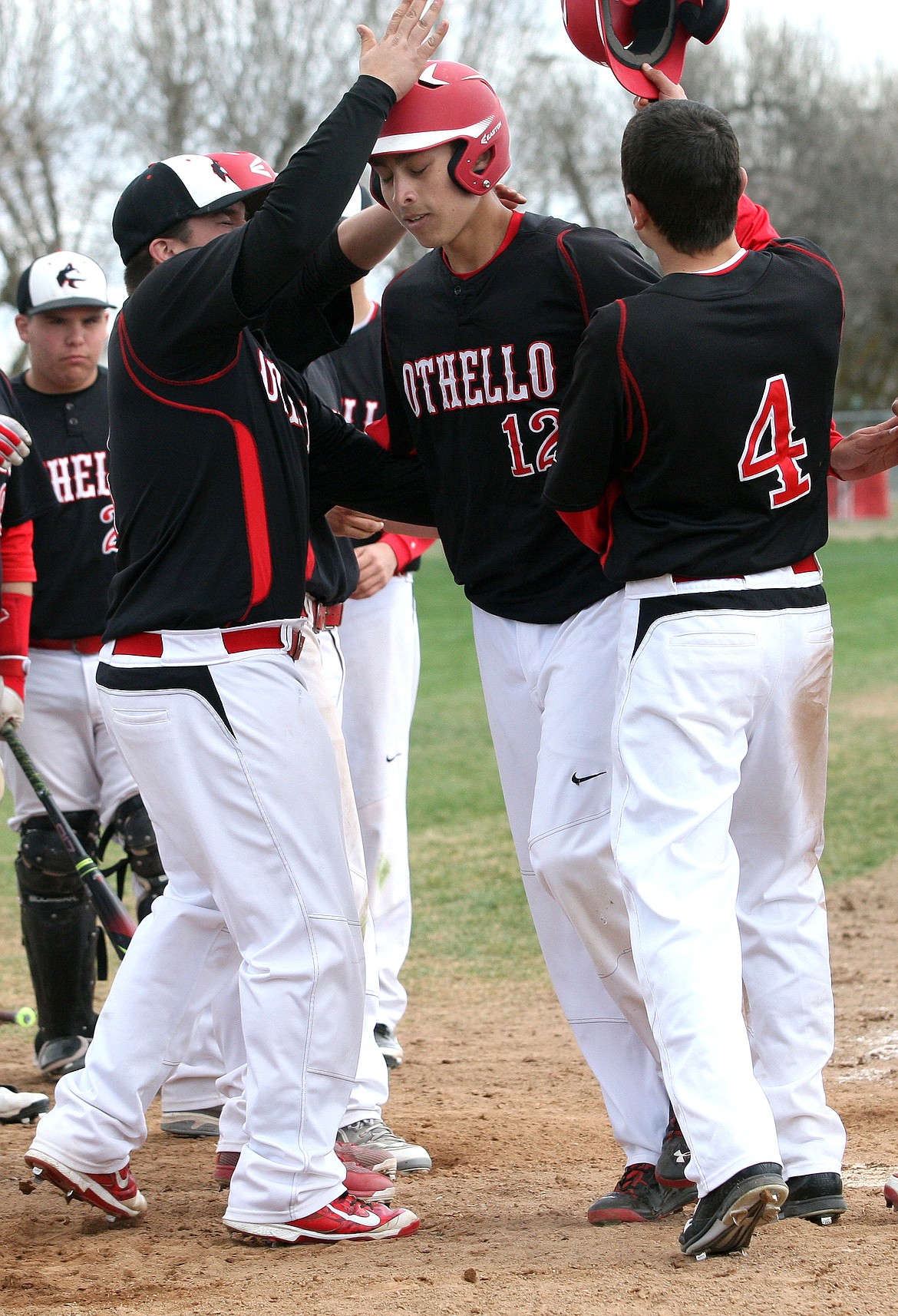 Rodney Harwood/Columbia Basin HeraldArcenio Martinez (12) of Othello is congradulated by teammates after hitting a three-run home run in the bottom of the seventh inning Saturday in the first game of a doubleheader with Ellensburg.
