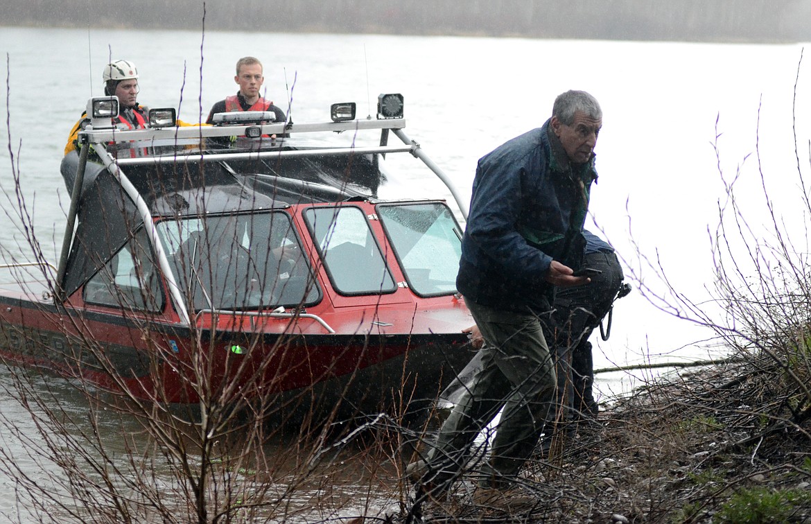 Flathead County Sheriff Chuck Curry talks with a search team Wednesday evening at the Old Steel Bridge on the Flathead River in Evergreen. (Matt Baldwin/Daily Inter Lake)