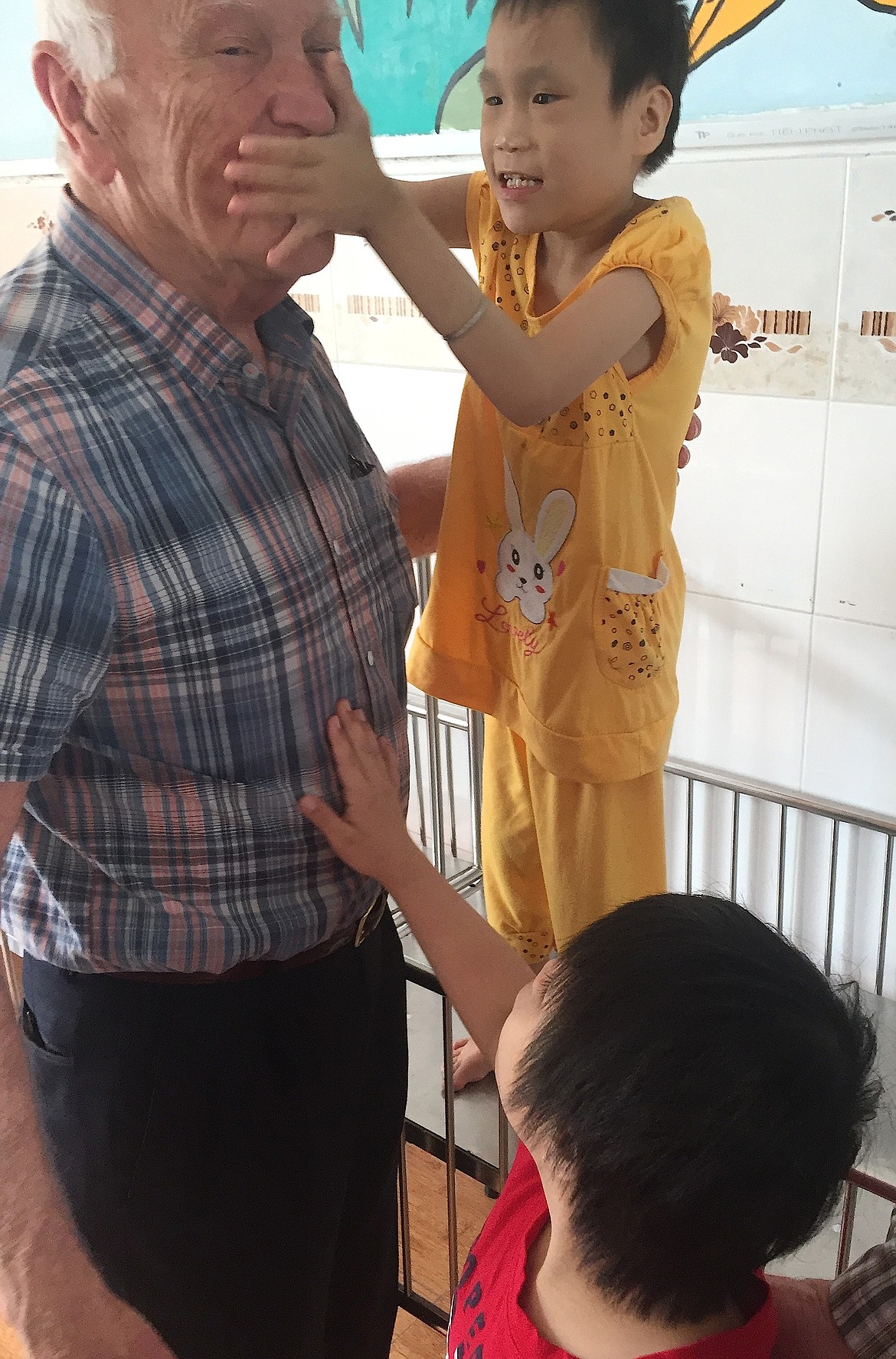 Courtesy photo
Dick Phenneger, of Post Falls and founder and president of the nonprofit Veterans Services Transparency, recently visited orphanages in Vietnam to learn the effects that the herbicide Agent Orange has had on generations. Phenneger at first didn&#146;t know that the child touching his face is blind.