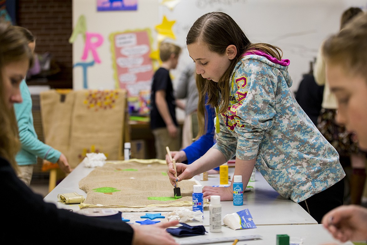 LOREN BENOIT/PressFifth-grader Isabella Burley paints a tree on a decorative table runner Thursday afternoon for Sorensen Magnet School's auction on April 29.