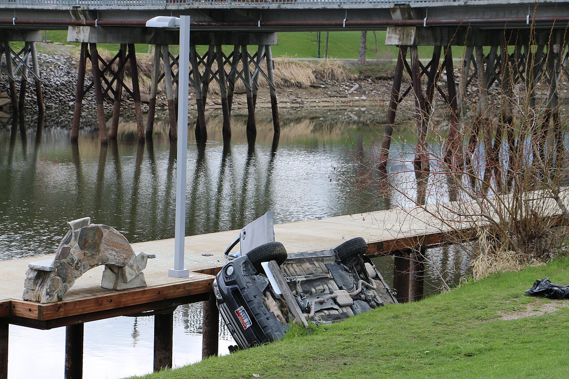(Photo by MARY MALONE)
A car rolled down and became wedged between the bank of Sand Creek and the dock at Gunnings Alley Friday.