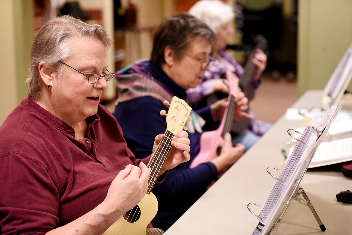 DENISE JENKE and members of a ukulele group practice in the meeting room of ImagineIF Library Tuesday, April 18, in Kalispell.
(Brenda Ahearn/Daily Inter Lake)