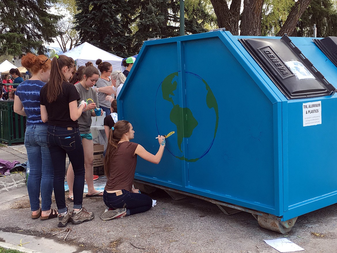 VISITORS TO the 2016 Flathead Earth Day Celebration paint a recycling bin provided by Valley Recycling. The bin is still in use &#151; collecting recyclable materials at the Flatehad County Fairgrounds. The third annual Earth Day is Saturday, April 22 at Whitefish Middle School. (Photo courtesy of Citizens for a Better Flathead)