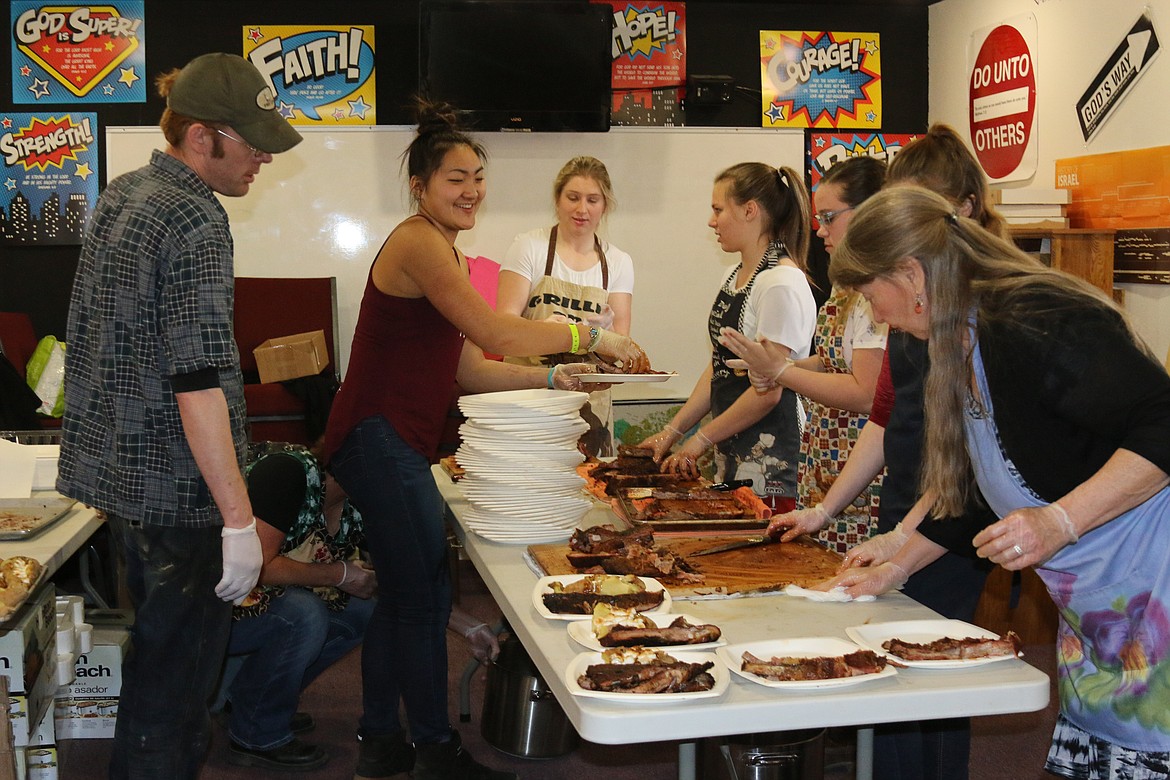 &#151;Photo by MANDI BATEMAN
Behind the scenes at the Sportsmen&#146;s Banquet. Pitmaster, Ken Bateman, supervises the rib-cutting crew.