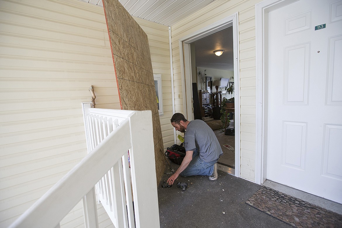 LISA JAMES/PressWhitewater Creek maintenance man Austin Parent replaces the door of a residence at the Silver Lake Apartments on Wednesday after an 8 hour SWAT team standoff the night before ended in the door being broken down and the locks shot off.